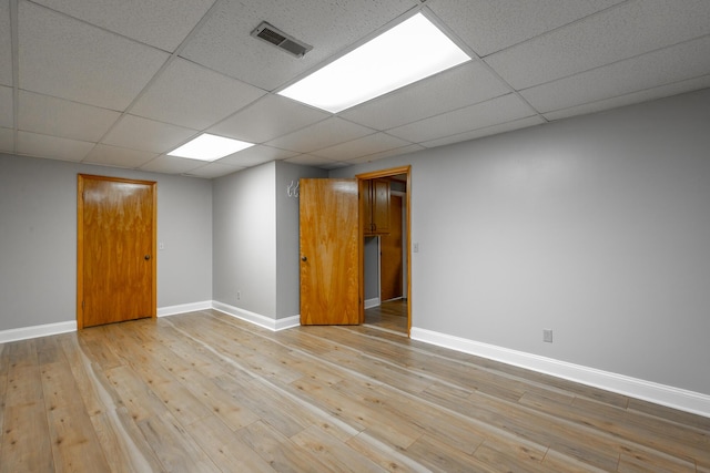 unfurnished room with light hardwood / wood-style floors and a drop ceiling