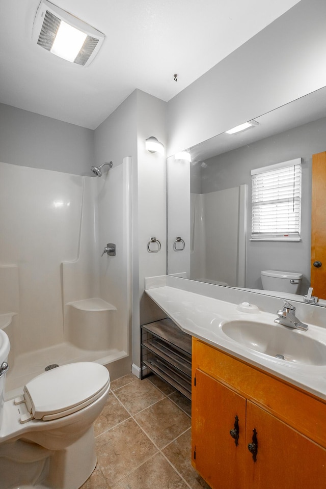 bathroom featuring vanity, tile patterned floors, toilet, and walk in shower