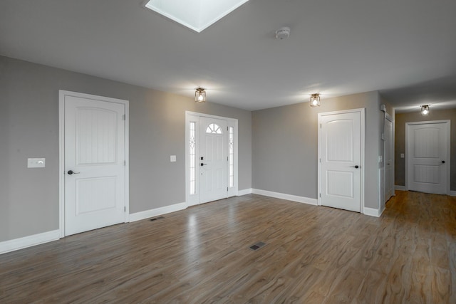 entryway with hardwood / wood-style flooring and a skylight