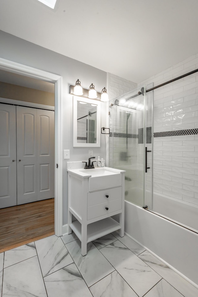 bathroom featuring bath / shower combo with glass door and vanity