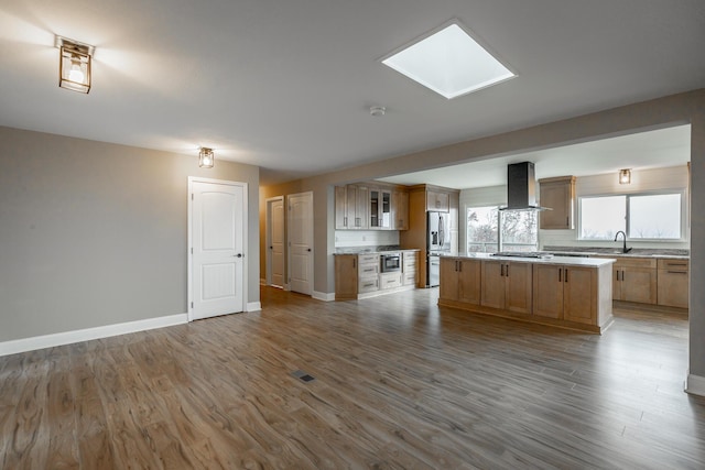 kitchen featuring hardwood / wood-style floors, sink, a kitchen island, and exhaust hood