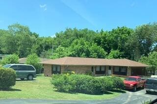 single story home featuring a front lawn