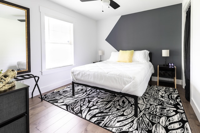 bedroom with multiple windows, dark wood-type flooring, and ceiling fan