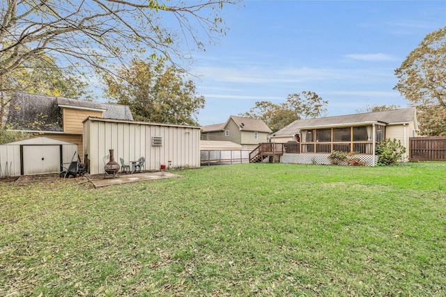 view of yard with a patio, a sunroom, a deck, and a shed