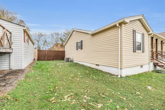 view of side of home with cooling unit and a lawn