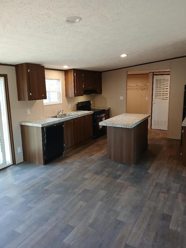 kitchen featuring a kitchen island, dark hardwood / wood-style floors, dark brown cabinetry, black appliances, and a textured ceiling