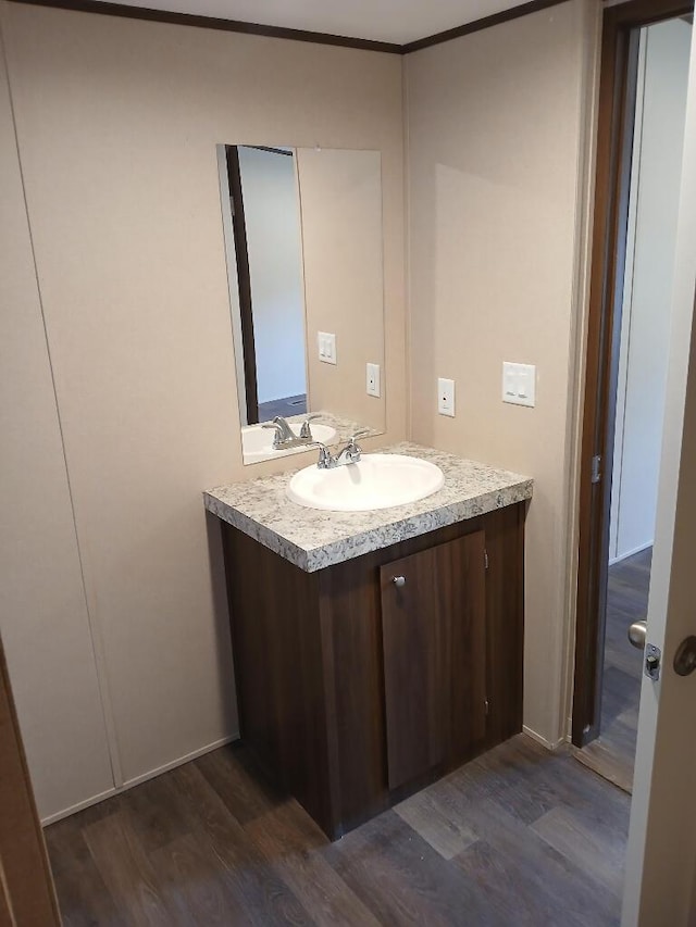 bathroom with vanity, hardwood / wood-style floors, and crown molding