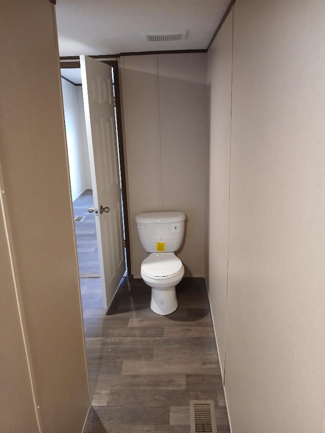 bathroom with hardwood / wood-style flooring and toilet