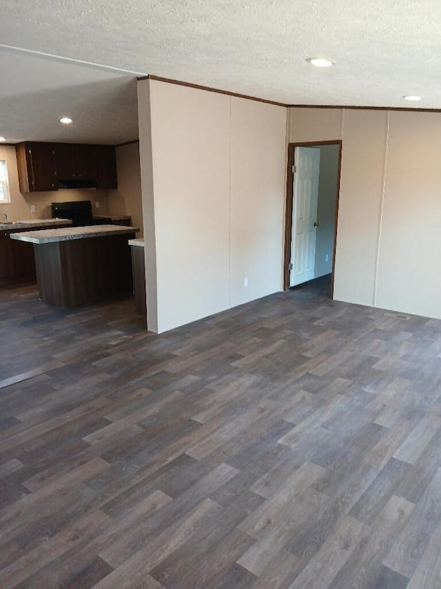 interior space with stove, dark brown cabinets, dark wood-type flooring, and a textured ceiling