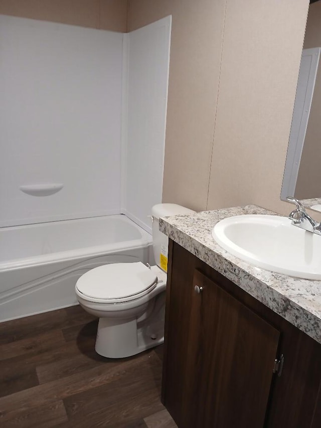 full bathroom with vanity, wood-type flooring,  shower combination, and toilet