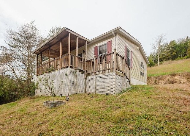 exterior space with a wooden deck and a lawn