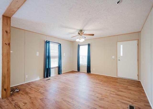 empty room featuring ceiling fan, a textured ceiling, and light wood-type flooring