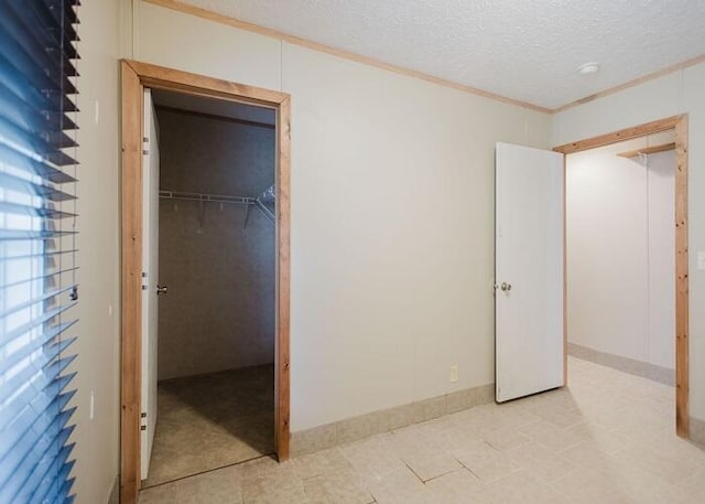 unfurnished bedroom with crown molding, a closet, and a textured ceiling