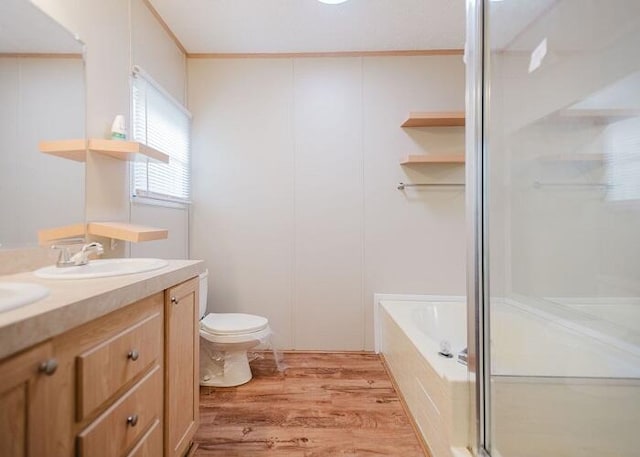 full bathroom featuring wood-type flooring, separate shower and tub, vanity, and toilet