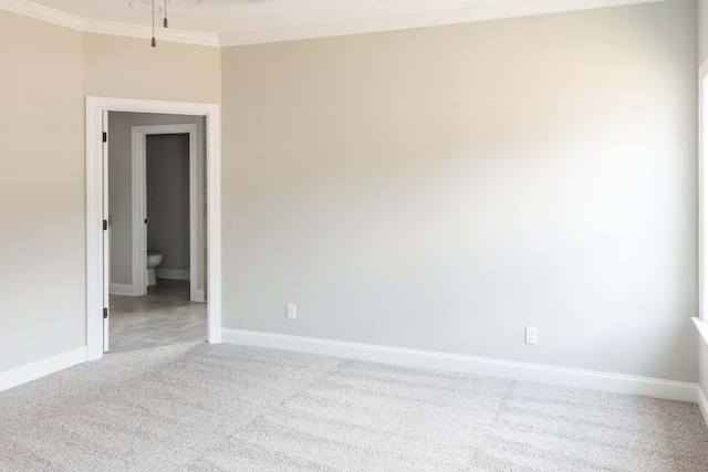 spare room featuring crown molding and light colored carpet