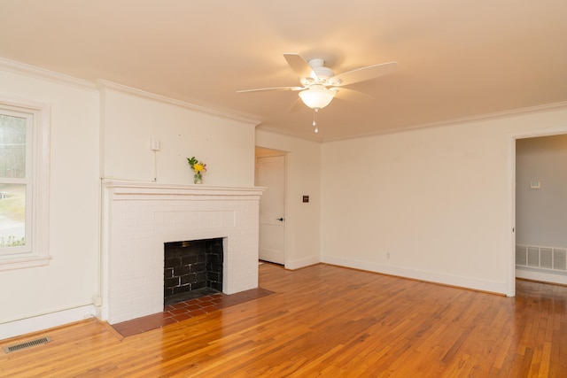 unfurnished living room featuring crown molding, wood-type flooring, and a fireplace