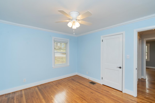 empty room with ornamental molding, ceiling fan, and light hardwood / wood-style floors