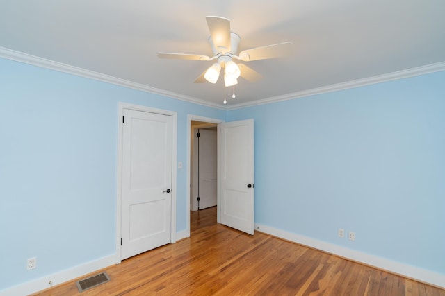 empty room featuring light hardwood / wood-style flooring, ornamental molding, and ceiling fan