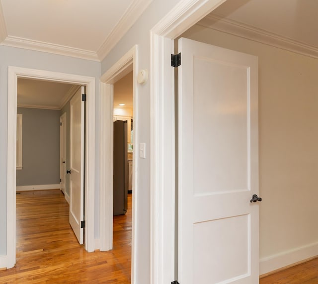 corridor with crown molding and light hardwood / wood-style floors