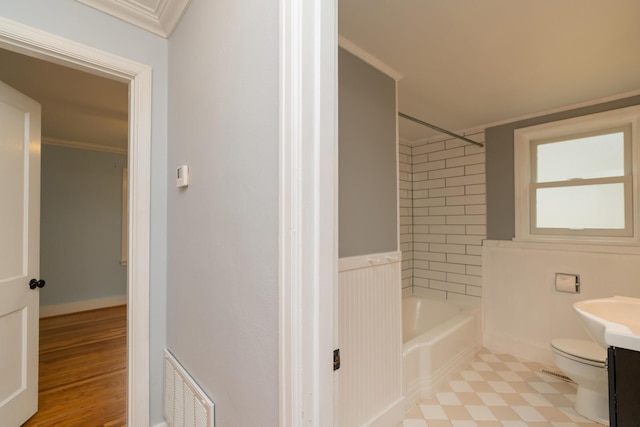 full bathroom featuring tiled shower / bath combo, ornamental molding, vanity, and toilet