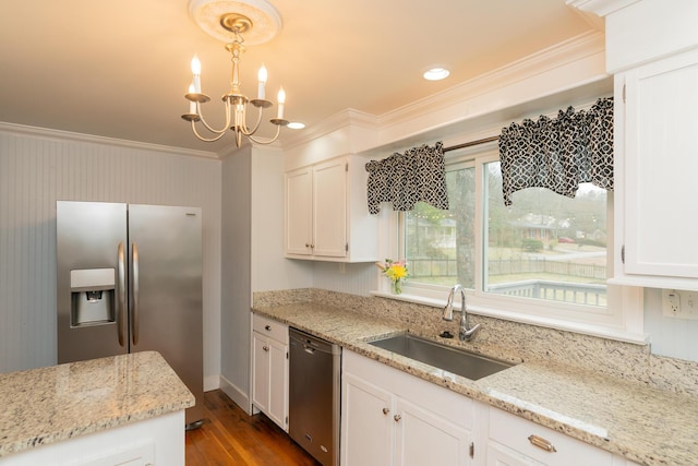 kitchen featuring pendant lighting, appliances with stainless steel finishes, light stone countertops, and sink