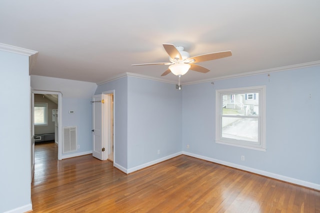 unfurnished room with crown molding, wood-type flooring, ceiling fan, and plenty of natural light