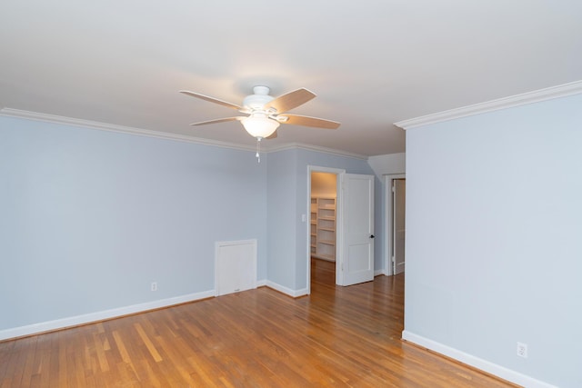 empty room featuring ceiling fan, ornamental molding, and wood-type flooring