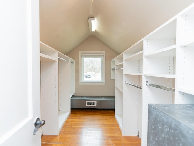 spacious closet with lofted ceiling and light hardwood / wood-style flooring