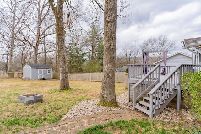 view of yard with a storage unit, a deck, and a fire pit