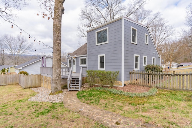 view of front of home with a deck and a front lawn