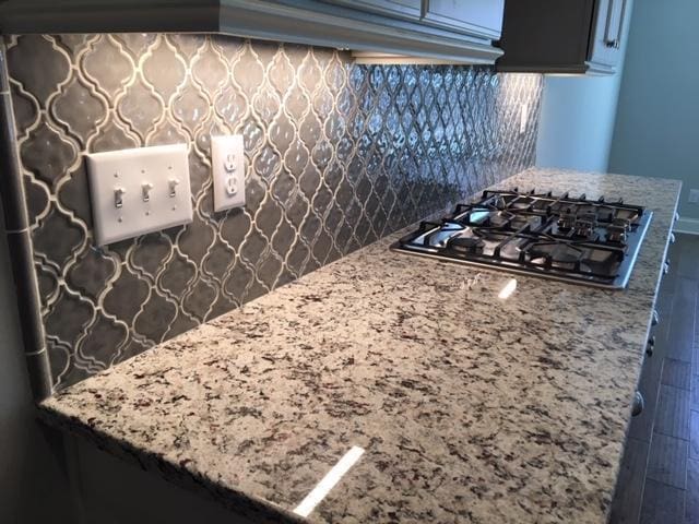 kitchen featuring backsplash and black gas cooktop