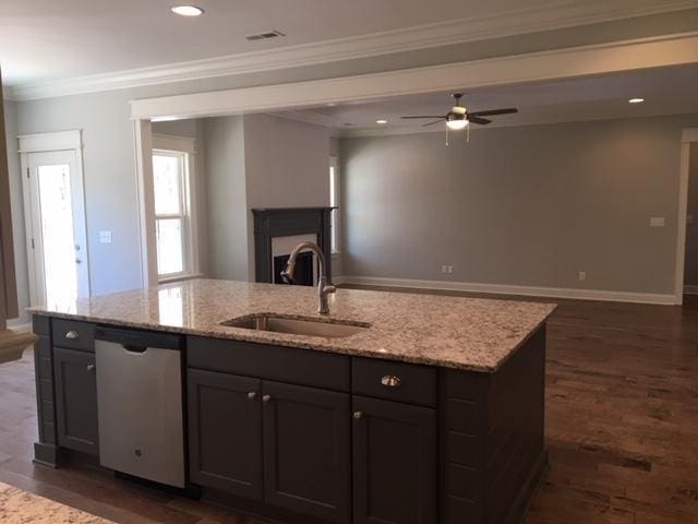 kitchen featuring light stone counters, sink, and stainless steel dishwasher