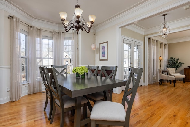 dining area featuring a notable chandelier, ornamental molding, light hardwood / wood-style floors, and french doors