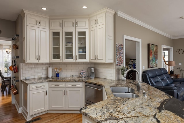 kitchen featuring sink, crown molding, tasteful backsplash, light wood-type flooring, and light stone countertops