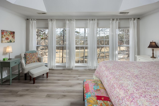 bedroom featuring ornamental molding and light hardwood / wood-style floors