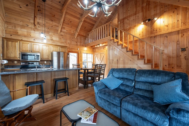 living room featuring beam ceiling, wooden walls, high vaulted ceiling, wood-type flooring, and wooden ceiling