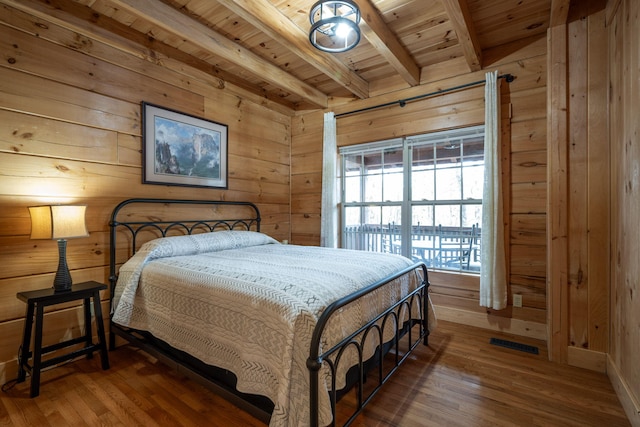 bedroom featuring wood ceiling, beam ceiling, wooden walls, and wood-type flooring