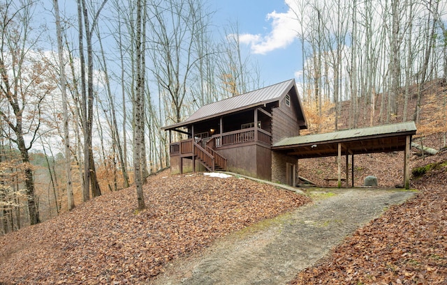 view of side of home featuring a carport and a porch