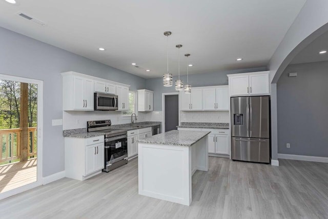 kitchen featuring pendant lighting, stainless steel appliances, and white cabinets