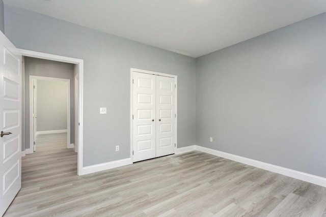 unfurnished bedroom with light hardwood / wood-style flooring and a closet