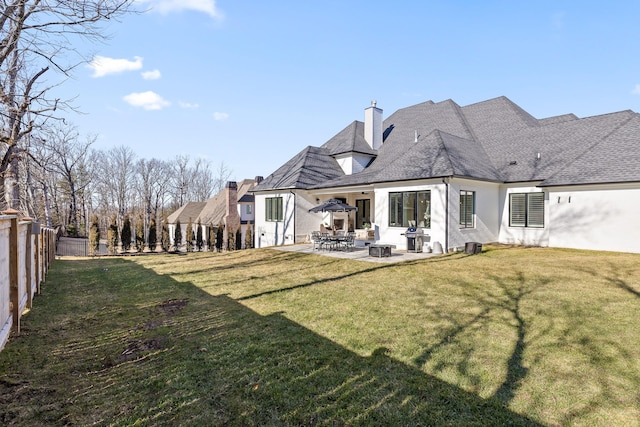 back of house with a yard and a patio