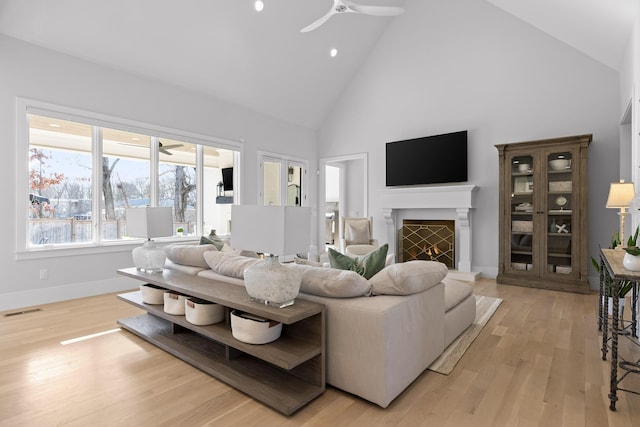 living room featuring high vaulted ceiling, light wood-type flooring, and ceiling fan