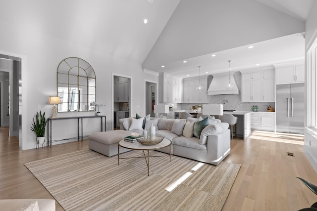 living room featuring light hardwood / wood-style flooring and high vaulted ceiling