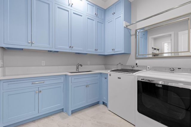 clothes washing area with cabinets, separate washer and dryer, and sink