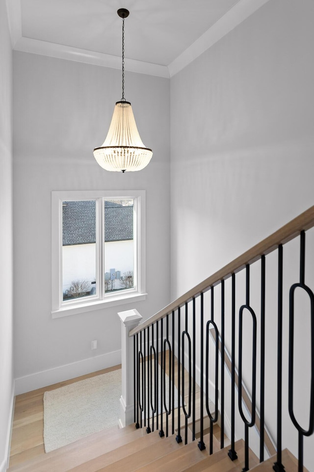 staircase with hardwood / wood-style flooring and ornamental molding