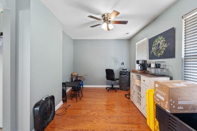 office space featuring ceiling fan, a textured ceiling, and light wood-type flooring