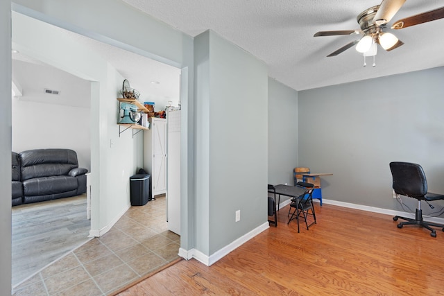 office space with ceiling fan, a textured ceiling, and light hardwood / wood-style floors