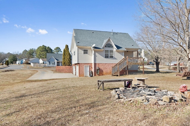 back of property with a wooden deck, a garage, a patio area, and a lawn