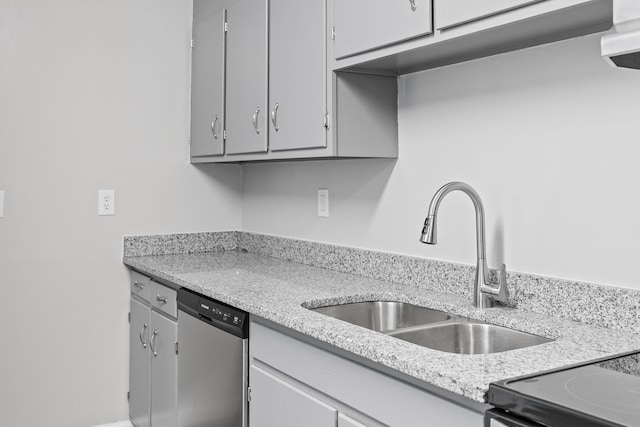 kitchen with light stone counters, sink, gray cabinets, and stainless steel dishwasher