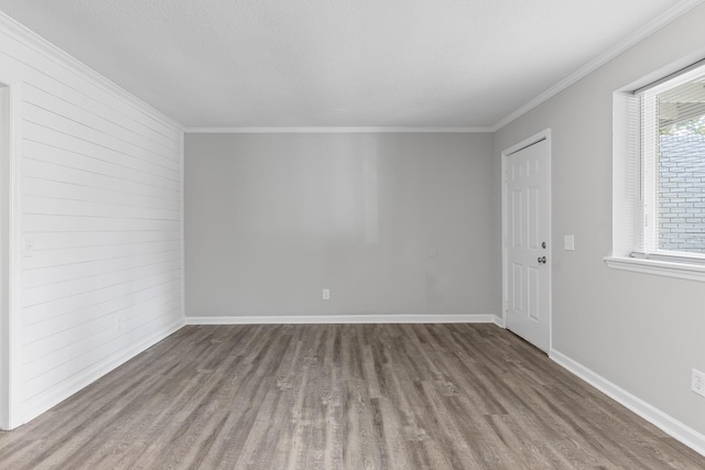 unfurnished room with hardwood / wood-style floors, crown molding, and a wealth of natural light